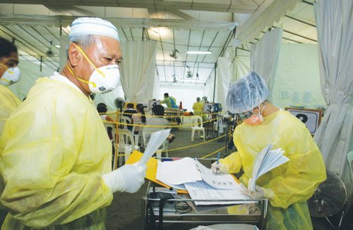 Singapore Health Emergency Department Staff On Duty In Full Personal Protective Equipment Of N95 Masks, Gowns And Gloves